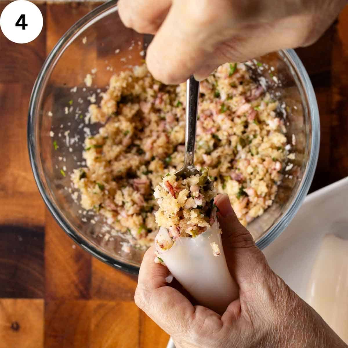 Bread crumb filling being stuffed into squid tube.