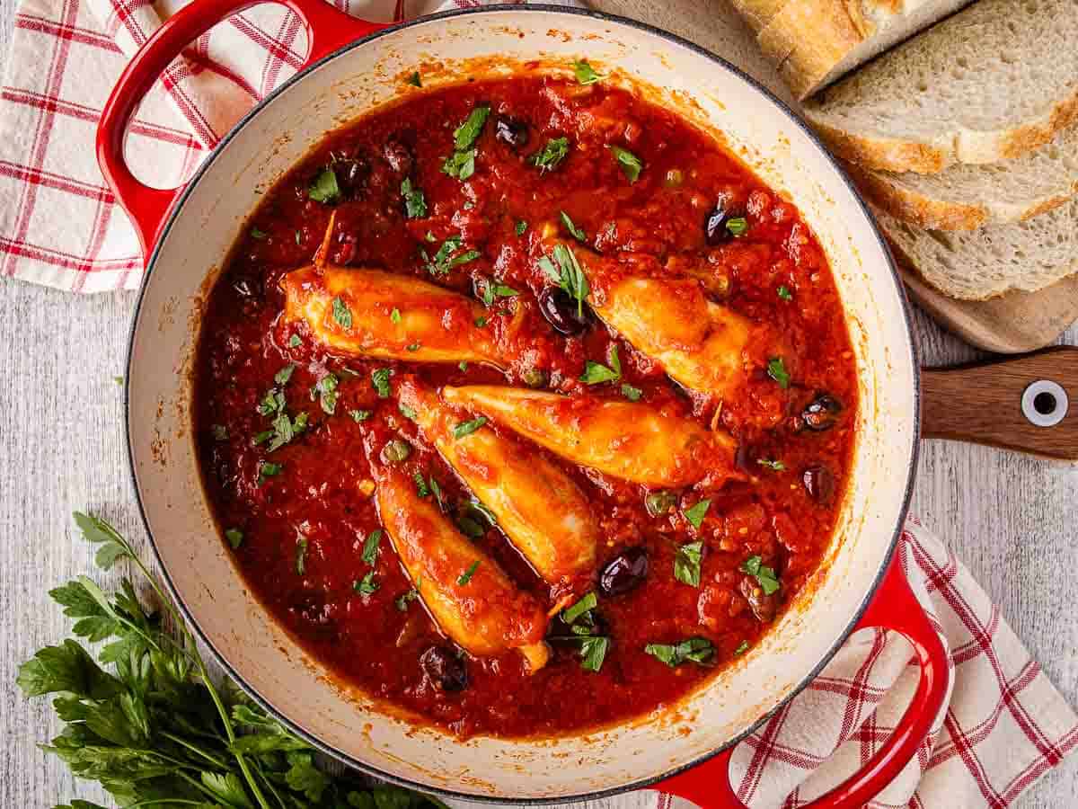 Filled squid tubes cooked in tomato sauce viewed from above.