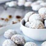 White sugar coated Norwegian cookies on blue plate plus more in white bowl.