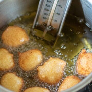 Donut balls frying in hot oil.