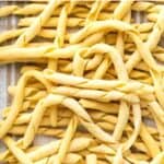 Busiate pasta on a kitchen towel viewed from above.