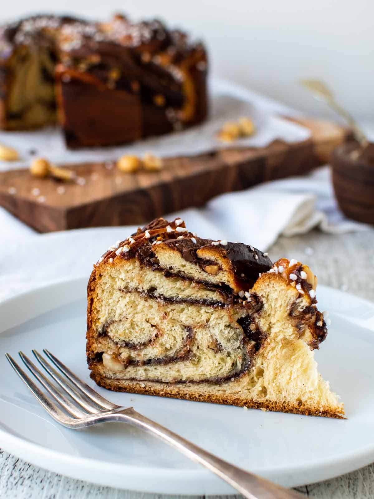Wedge of nutella bread with swirls of chocolate inside on a white plate.