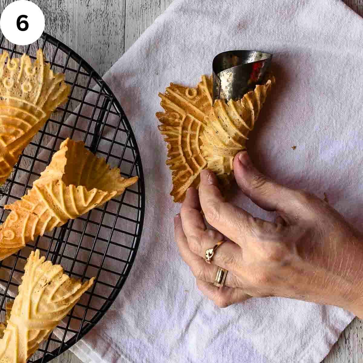 Rolling thin waffles around a metal cone shaped mold.