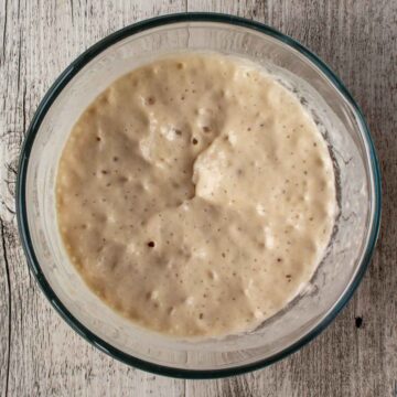 Bubbly batter in a glass bowl viewed from above.