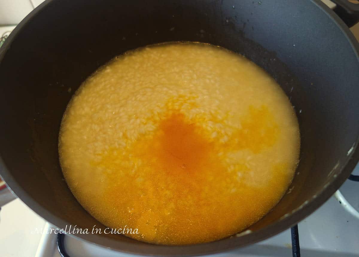 Adding steeped saffron to risotto.