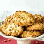 Pignoli Cookies on a white plate with a stand.