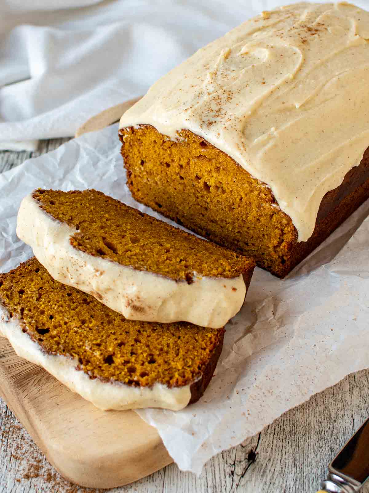 Pumpkin Bread with Cream Cheese Frosting with two slices cut.