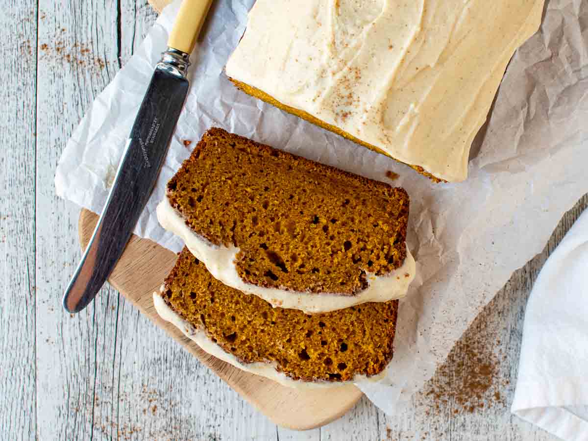 Overhead view of pumpkin loaf cake with two slices cut.