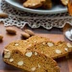 two Italian Piparelli - spicy cookies with glass of liqueur and a plate of cookies in the background
