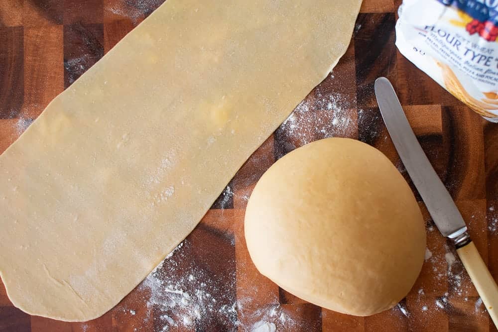 Making fresh pasta a home requires only two ingredients - flour and eggs. Learn how to make your own egg pasta with this step by step recipe. #homemade #homemadepasta #eggpasta #italianrecipe #pastarecipe Pasta dough, rolled sheet of pasta, knife and flour.