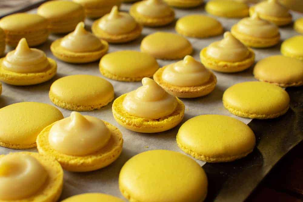Lemon Macarons #lemonmacarons #lemon #macarons #macaron Yellow macarons halves topped with lemon filling