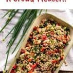 image with text. text reads "brown rice salad a crowd pleaser". image is Brown rice salad in oblong plate with spring onions and lemon.