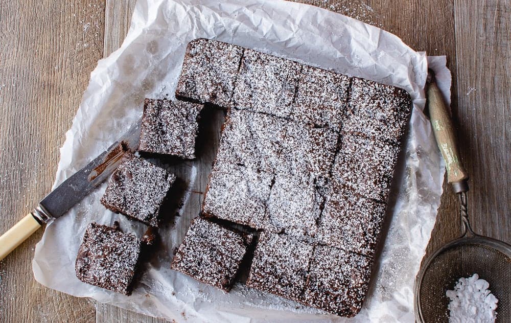 This Easy Brownies recipe with cocoa powder is rich and deliciously fudgy. You'll love this homemade, one-bowl recipe. #brownies #cocoabrownies #easybrownies #chocolatebrownies The finished brownies coated with sugar and cut into squares