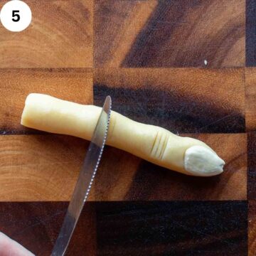 Cookie dough shape like a finger with almond for a fingernail.