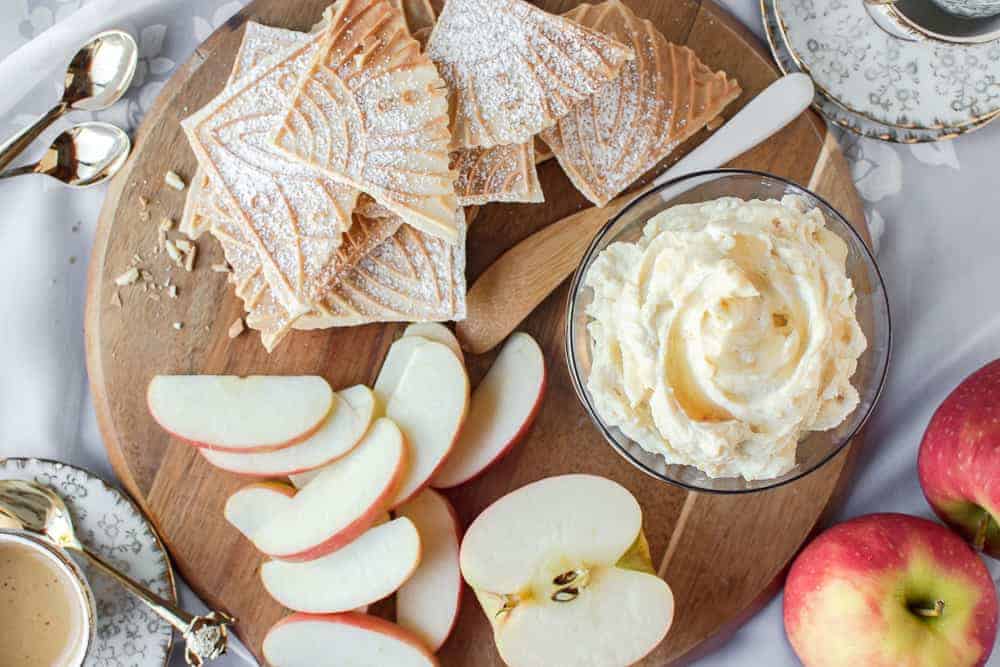 This Sweet Ricotta is flavoured with orange rind and honey. A delicious dip with fresh fruit and sweet cookies. #sweetricotta #honeyricotta #sweetdip #ricotta sweet ricotta on a board with apple slices and pizzelle.