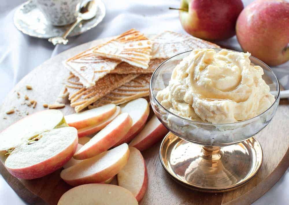 This Sweet Ricotta is flavoured with orange rind and honey. A delicious dip with fresh fruit and sweet cookies. #sweetricotta #honeyricotta #sweetdip #ricotta creamy ricotta on a board with apple slices and pizzelle.