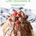 christmas ice cream pudding with chocolate drip decorated with chocolates and raspberries
