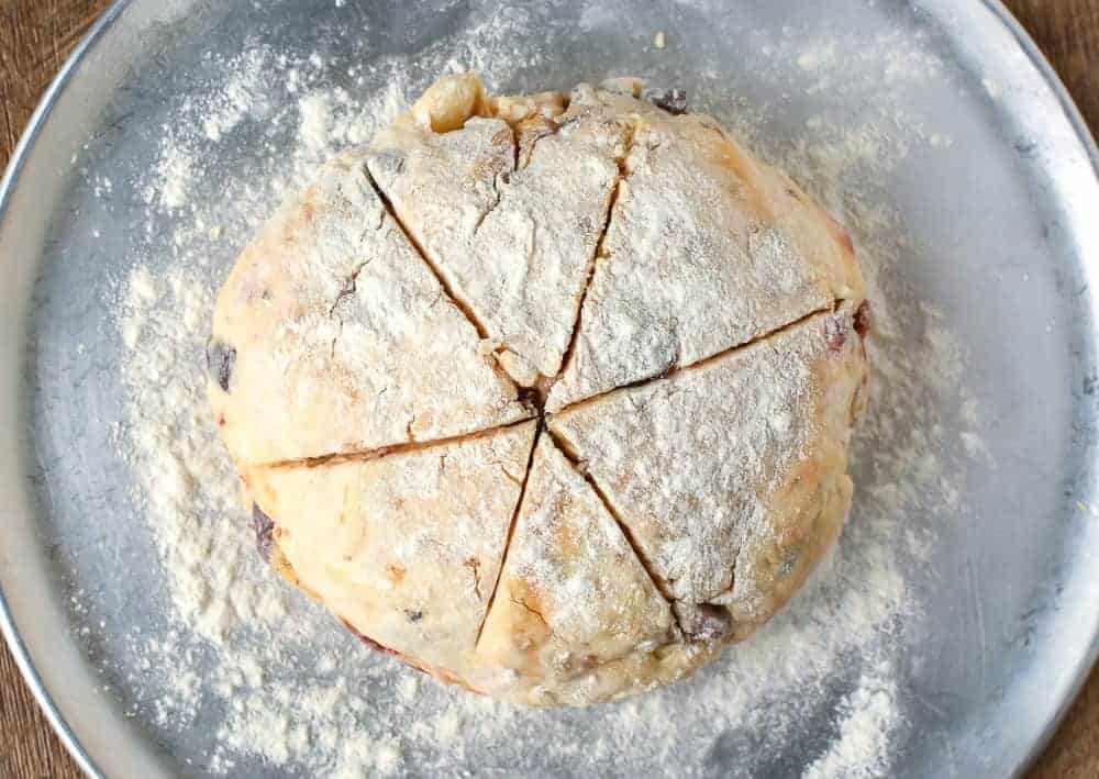Damper with olives, sun dried tomatoes and cheese is tasty, quick and delicious #damper #quickbread #sodabread #recipe #italianfood #australianfood Ball of damper dough on aluminum round tray viewed from above.