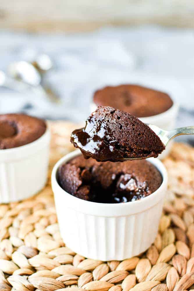 An easy Chocolate Pudding Recipe that is so rich, gooey and decadent! These puddings a super quick to make. #chocolatepuddingrecipe #chocolatepudding #chocohotopots #nigellasrecipes #chocolatedessert Close up of a spoonful of gooey baked chocolate pudding