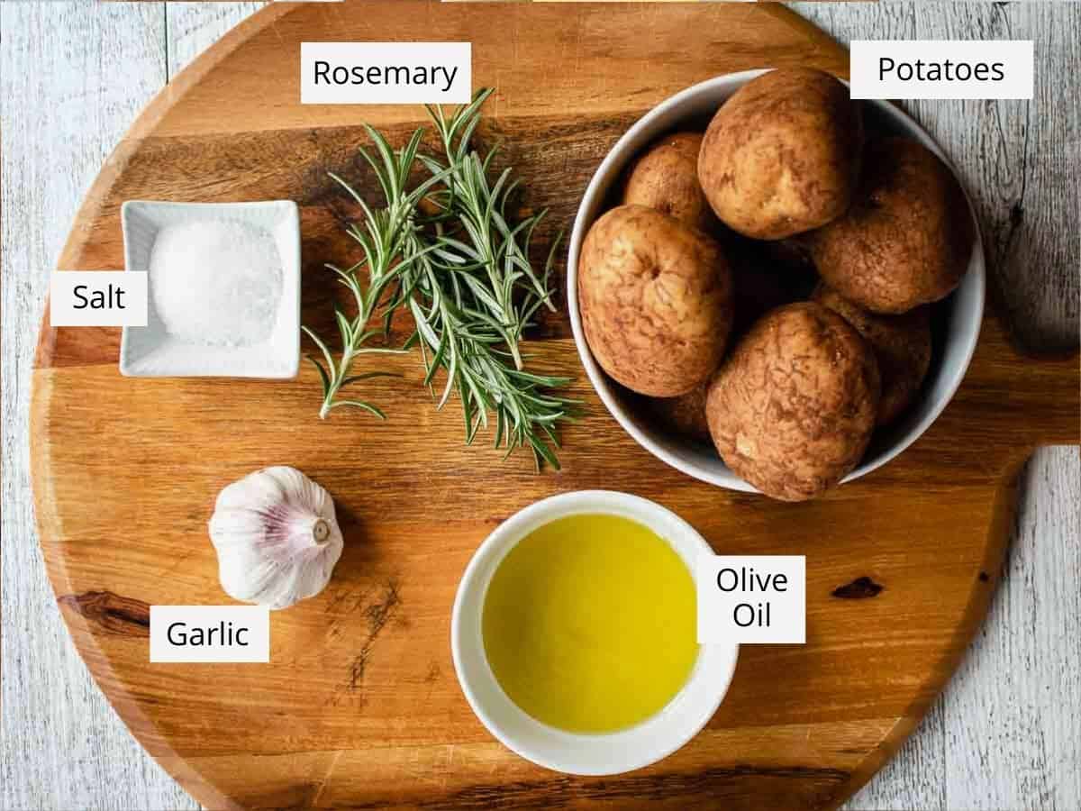 These crispy roast Potatoes are crispy and crunchy. Roasted with garlic and rosemary these potatoes are the perfect side dish. #roastedpotatoes #roasted #potatoes #sides Ingredients for this recipe as in the recipe card viewed from above.