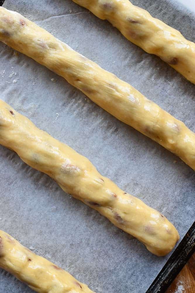 Italian Almond biscotti are easy to make at home. They are crunchy and perfect for dipping in vin santo or an espresso. #italianrecipe #almondbiscotti #italianalmondbiscotti #biscottirecipe four uncooked logs of dough on baking paper viewed from above.