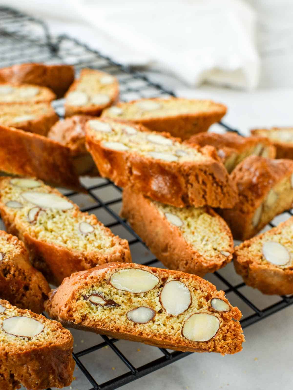 Italian Almond biscotti are easy to make at home. They are crunchy and perfect for dipping in vin santo or an espresso. #italianrecipe #almondbiscotti #italianalmondbiscotti #biscottirecipe Cantucci on black wire rack.