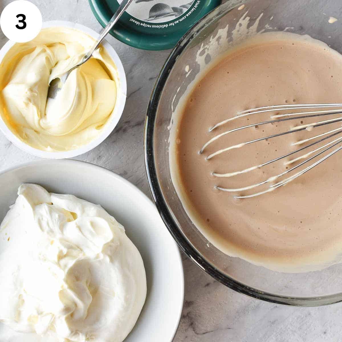 Prepared Marsala zabaglione in a bowl with bowls of mascarpone cream and whipped cream beside.
