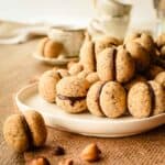 Baci di Dama cookies piled onto a white plate.