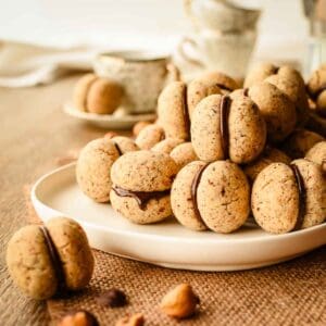 Baci di Dama cookies piled onto a white plate.