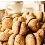 Baci di Dama cookies piled onto a white plate.