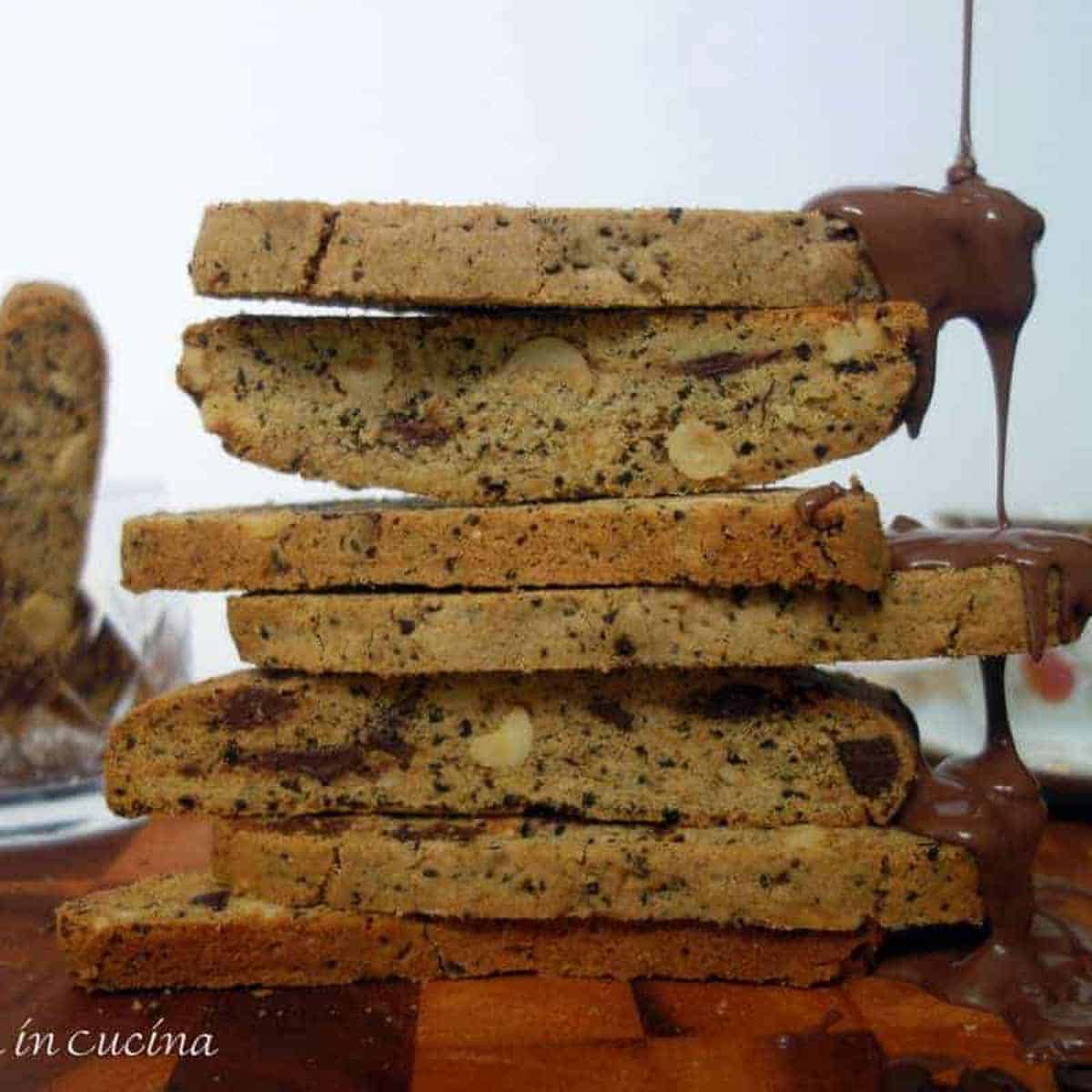 Coffee biscotti stacked with chocolate dripping down one side.