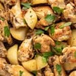 Image with text. Text reads "Italian Style Braised Chicken". Image is close up of braised chicken wings with potato chunks sprinkled with chopped parsley viewed from above