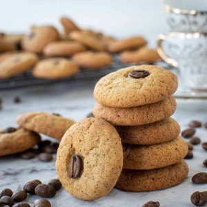 Coffee cookies stacked with one cookie leaning on the stack.