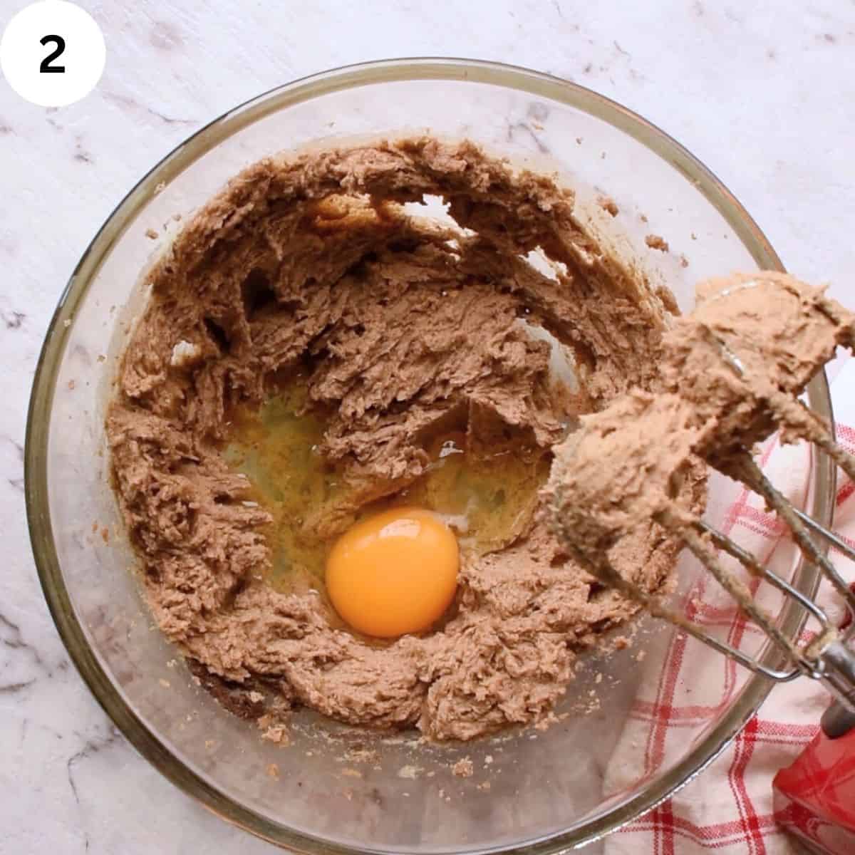 Egg broken into cream butter and sugar.