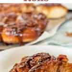 Image with text. Text reads " Homemade caramel cinnamon rolls". Image is one roll on a white plate, more rolls in background.