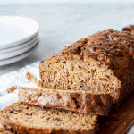 Image and text. Text reads "easy and quick date bread". Image is date bread on wooden board with three slices cut