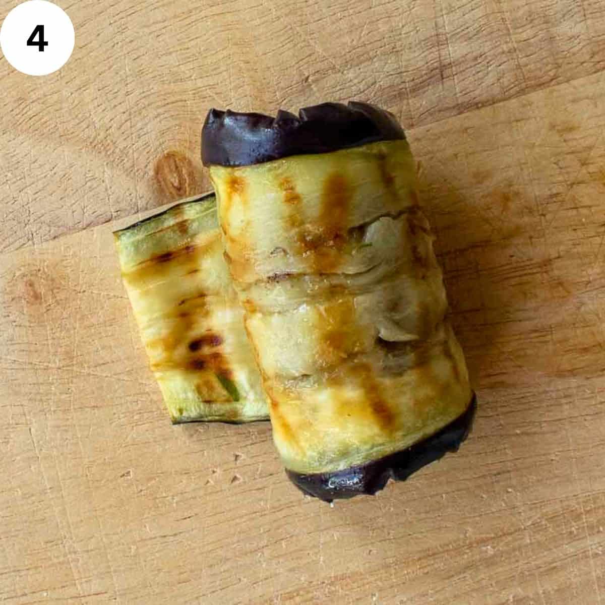 A slice of grilled eggplant rolled up.