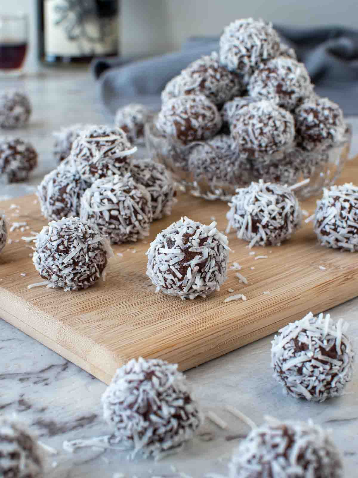 Several of my rum balls recipe piled in a wooden board.