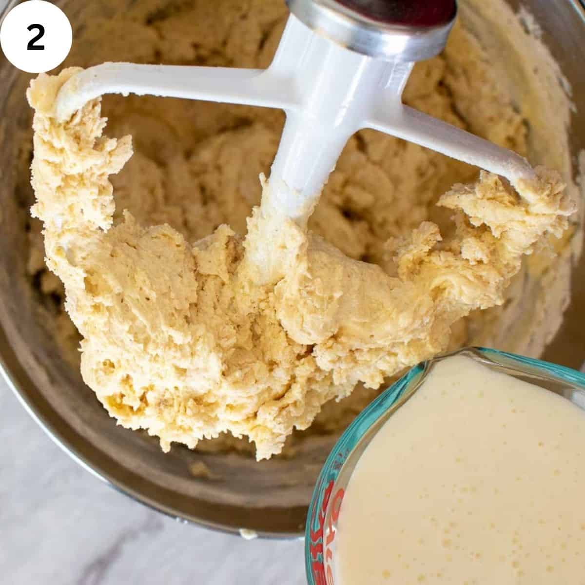 Cake batter clinging to electric mixer paddle.