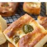 image with text. text reads "focaccia genovese tasty italian recipe". Image is close up of focaccia bread with green olives on top and sliced onions on other pieces with more focaccia in the background