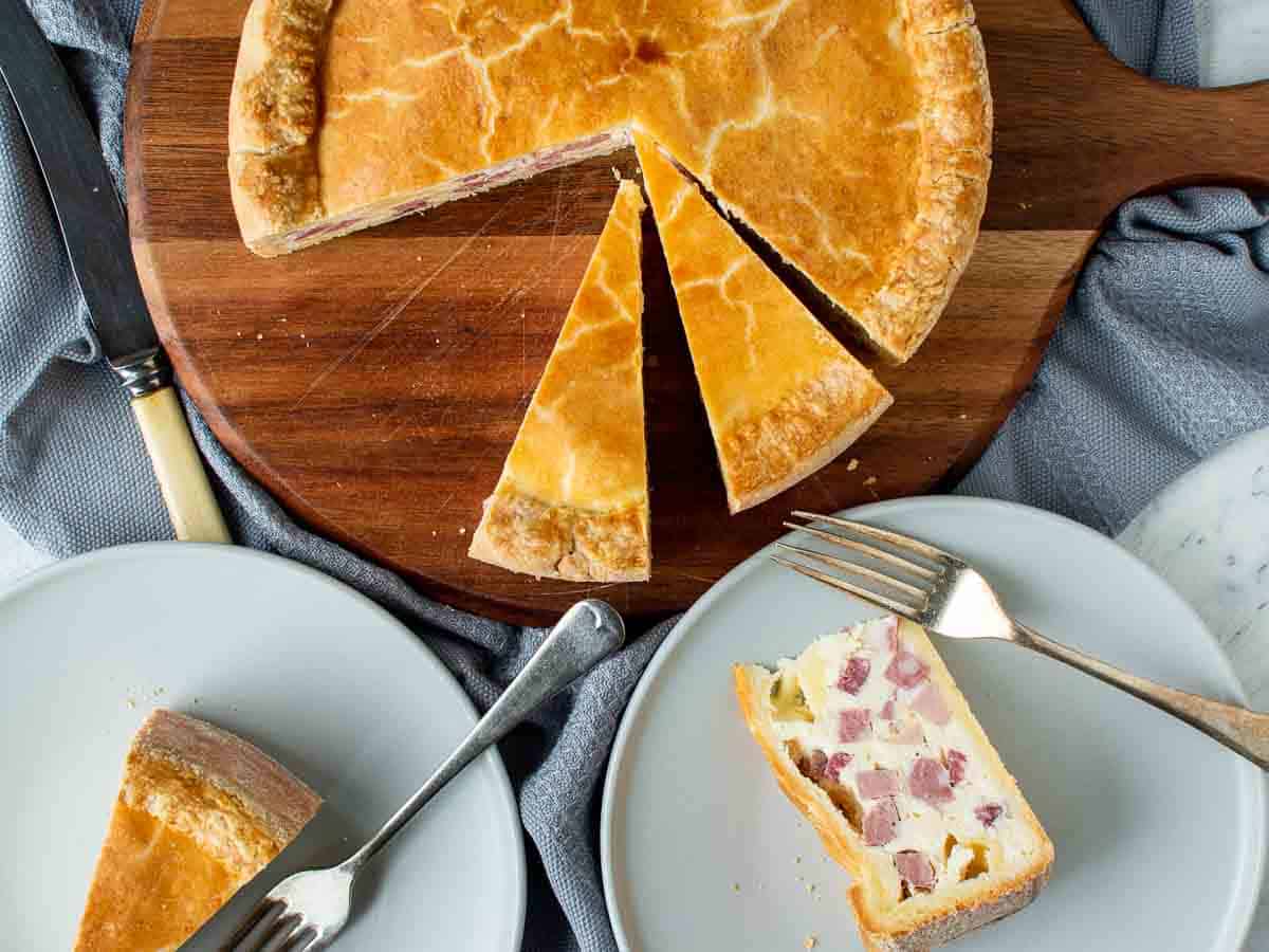 Filled pastry pie with two wedges cut; one wedge on its side on plate viewed from above.