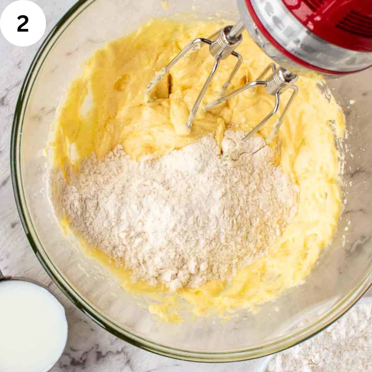 Mixing flour into a cream butter and sugar mixture.