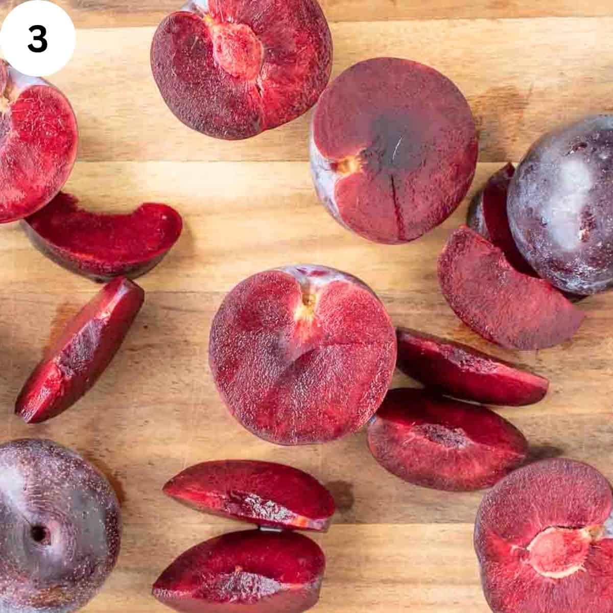 Fresh plums whole, in half and sliced.