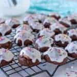 white frosting covered chocolate cookies on wire rack.