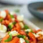 images with text. text reads "italian classic bruschetta with mozzarella. image is bruschetta with tomatoes and mozzarella on white plate.