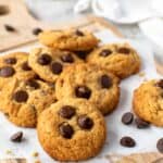 Almond flour peanut butter cookies topped with chocolate chips on white baking sheet.