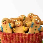 image with text. text reads "gingerbread cookies without molasses". image is gingerbread people in red box surrounded by green leaves and red cord.