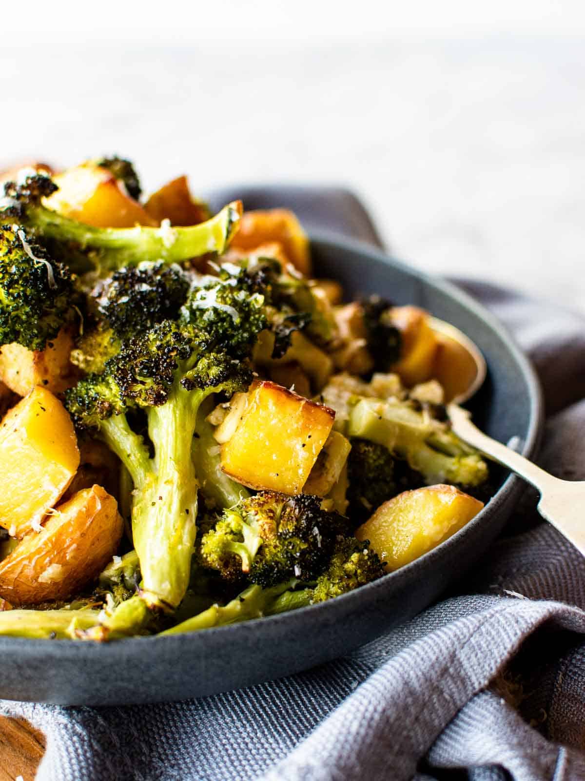 close up of roasted potatoes and broccoli in a bowl.