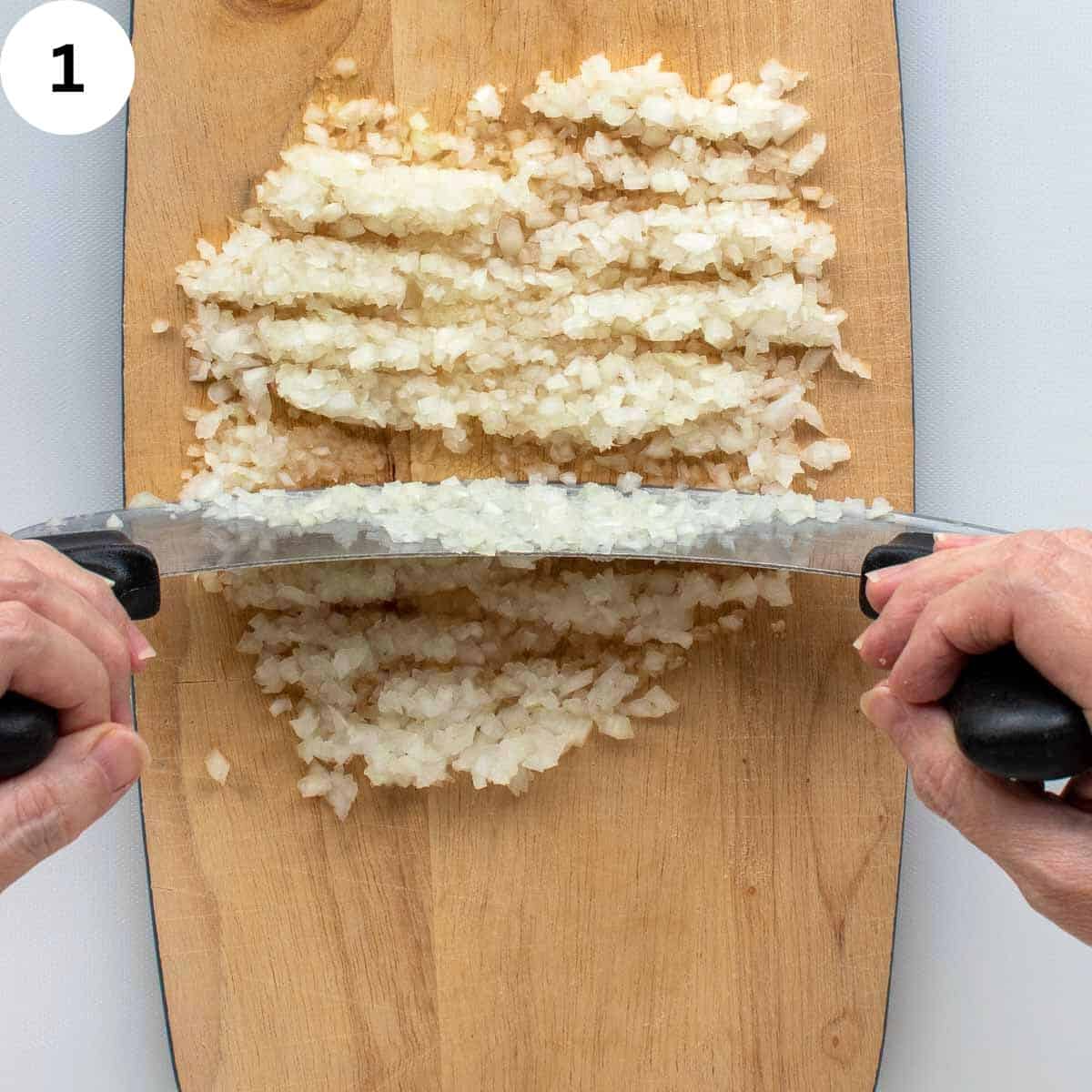 Finely chopping onions with rocking knife.