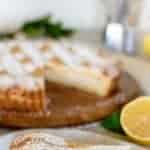 image with text. text reads "perfectly creamy Italian ricotta pie". slice of pie on white plate with gold fork and whole pie in the background.